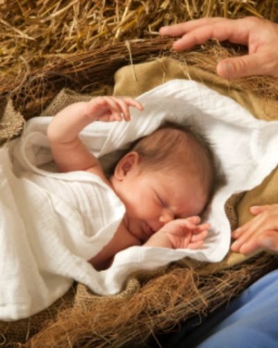 20 days old baby sleeping in a christmas nativity crib