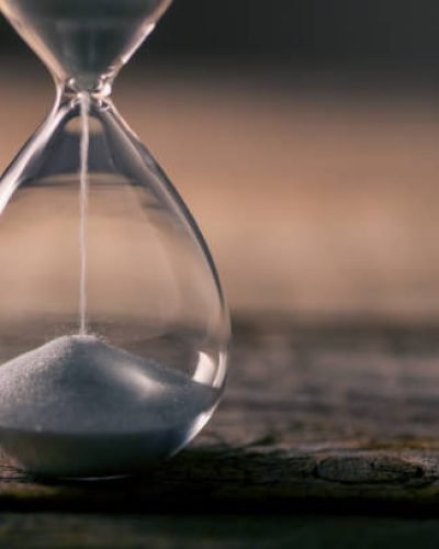 Flowing  white hourglass on wooden table; Twilight blue