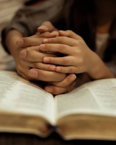 a kid reading the holy bible with guide by parents